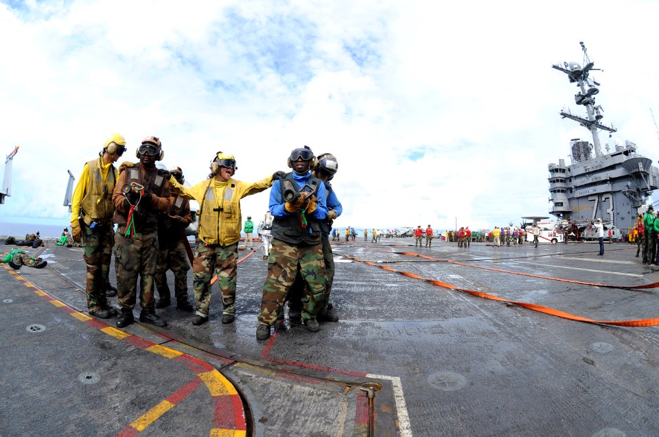 US Navy 100930-N-7191M-004 Hose team members move in to fight a simulated fire during a mass casualty drill aboard the aircraft carrier USS George