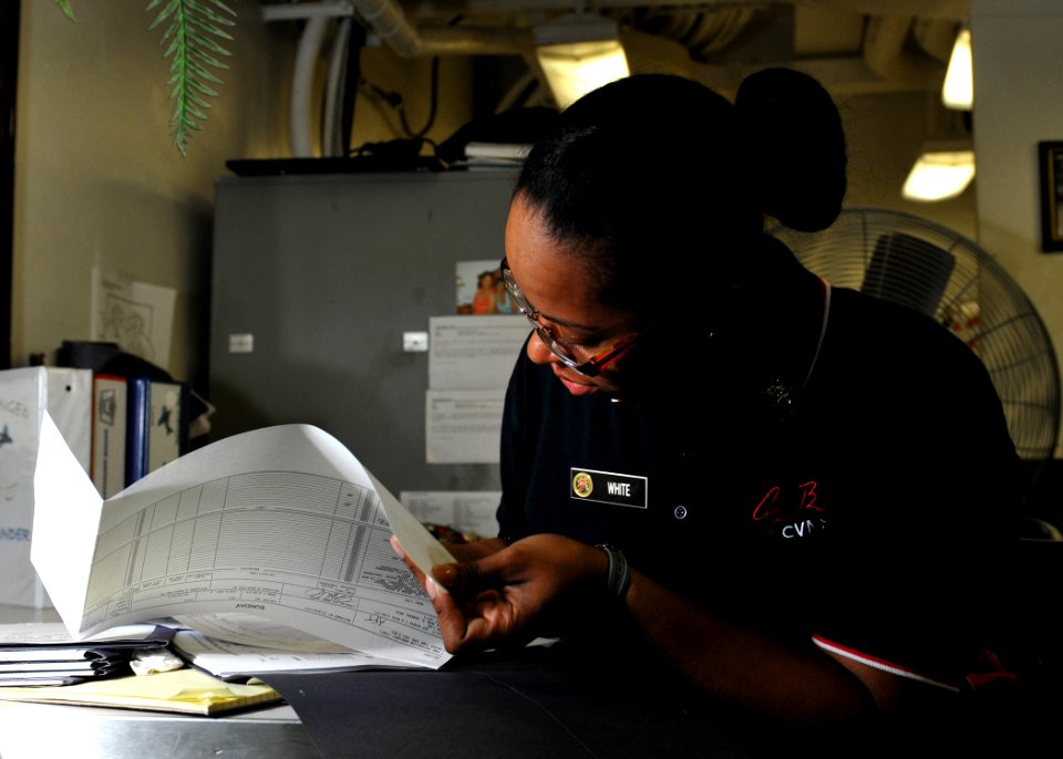US Navy 101006-N-3374C-039 Culinary Specialist 2nd Class Melody White, assigned to the supply department's S-2 division, fills out a food supply fo