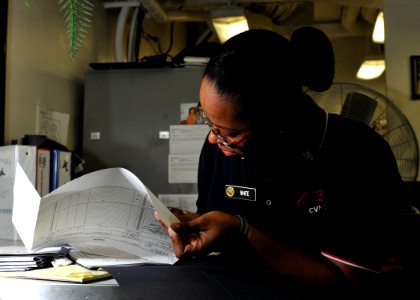 US Navy 101006-N-3374C-039 Culinary Specialist 2nd Class Melody White, assigned to the supply department's S-2 division, fills out a food supply fo