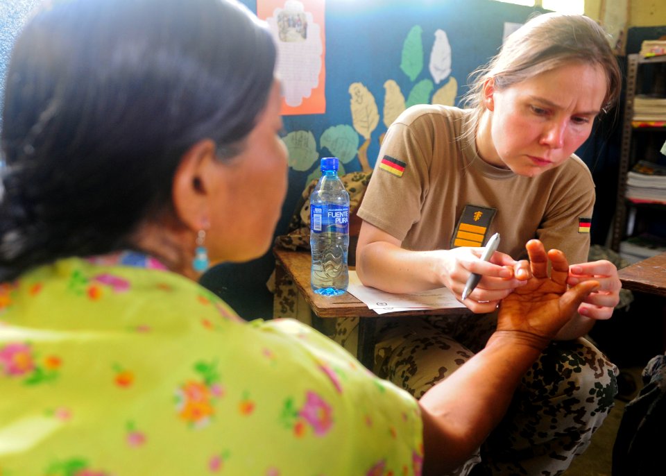 US Navy 101001-N-1531D-064 Cmdr. Diana Seemann examines a woman's fingers during a Continuing Promise 2010 medical community service event
