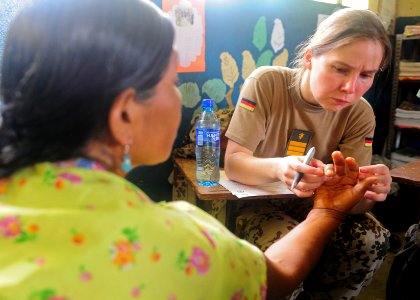 US Navy 101001-N-1531D-064 Cmdr. Diana Seemann examines a woman's fingers during a Continuing Promise 2010 medical community service event photo