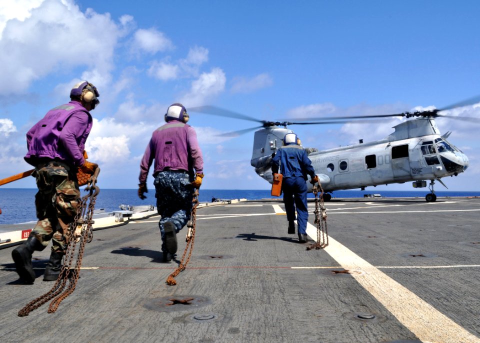 US Navy 100929-N-3620B-072 Sailors rush to chock and chain a CH-46E Sea Knight helicopter after landing on the flight deck of USS Denver (LPD 9)