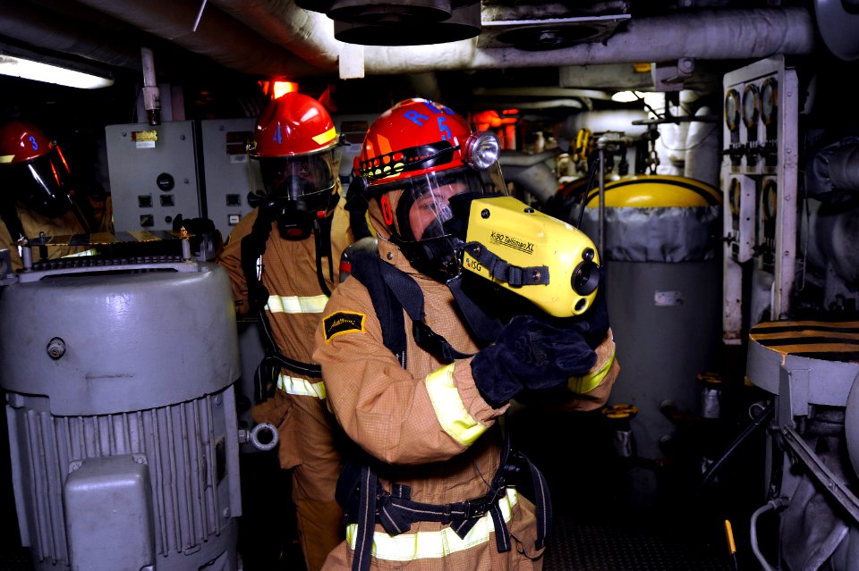 US Navy 101002-N-8335D-023 Damage Controlman 3rd Class Matthew Barrera uses a naval infrared thermal imager to check an engine room for hot spots d