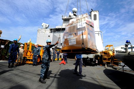 US Navy 100930-N-8335D-331 Seaman Rachel Mackey guides a pallet of stores as it is craned aboard USS Harpers Ferry (LSD 49).