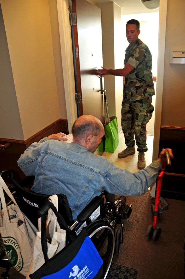 US Navy 101004-N-7367K-007 Equipment Operator 3rd Class Jacob McNamare, assigned to Naval Mobile Construction Battalion (NMCB) 74, helps retired Ar photo