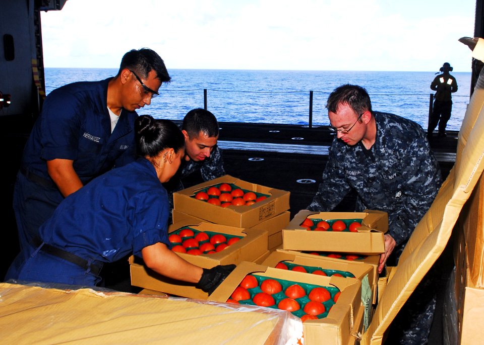 US Navy 101002-N-2218S-132 Sailors move tomatoes aboard USS Essex (LHD 2) during a replenishment at sea