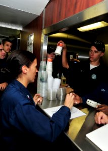 US Navy 101006-N-0569K-001 Boatswain's Mate 3rd Class Maeghan A. Antunes orders a cup of coffee from the newly opened Starboard Joe's coffee shop a