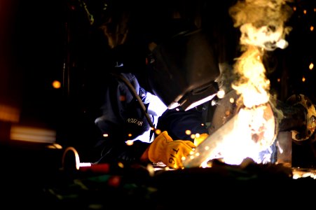 US Navy 101007-N-8335D-977 Hull Maintenance Technician 1st Class Ian Acuzar welds with a shielded metal arc welder aboard the amphibious dock landi