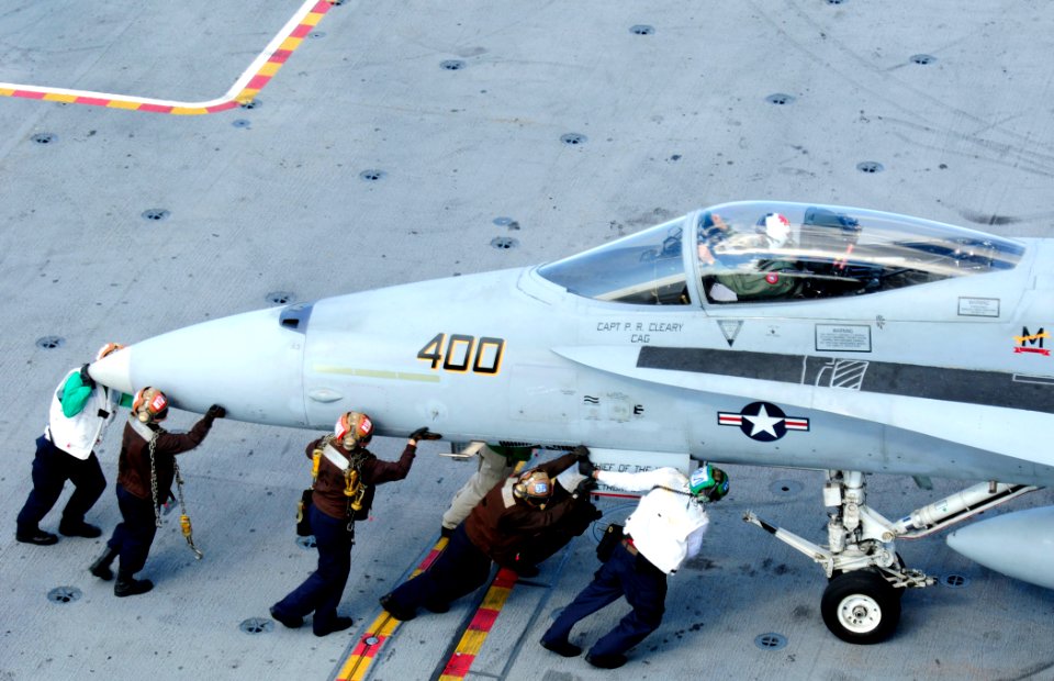 US Navy 101005-N-8913A-205 Sailors move an F-A-18A- Hornet, assigned to the Golden Warriors of Strike Fighter Squadron (VFA) 87