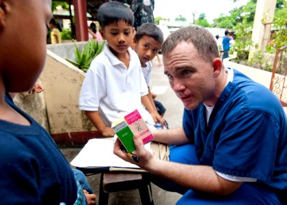 US Navy 101007-N-6770T-181 Hospital Corpsman 2nd Class Shawn P. Cairy, a reserve component Sailor, explains medications he is giving to a Filipino photo