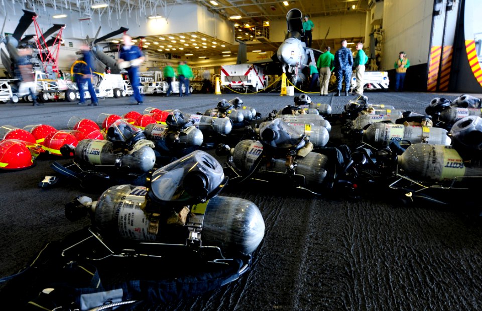 US Navy 101007-N-8913A-167 ailors work nearby firefighting equipment in the hangar bay of the aircraft carrier USS George H.W. Bush (CVN 77)