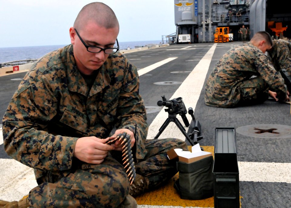 US Navy 101006-N-8113T-006 Lance Cpl. Richard Pobocik loads ammunition rounds for an M-240 machine gun qualification aboard USS Denver (LPD 9)