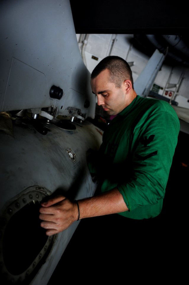 US Navy 101011-N-3793B-041 Aviation Machinist's Mate 3rd Class Robert Leggett installs a pre-check valve in an F-A-18C Hornet aboard the aircraft c