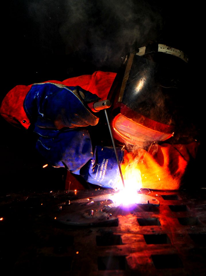 US Navy 101013-N-7948R-254 Hull Technician Fireman Tristan Reynolds arc-welds a flange aboard the amphibious dock landing ship USS Pearl Harbor (LS