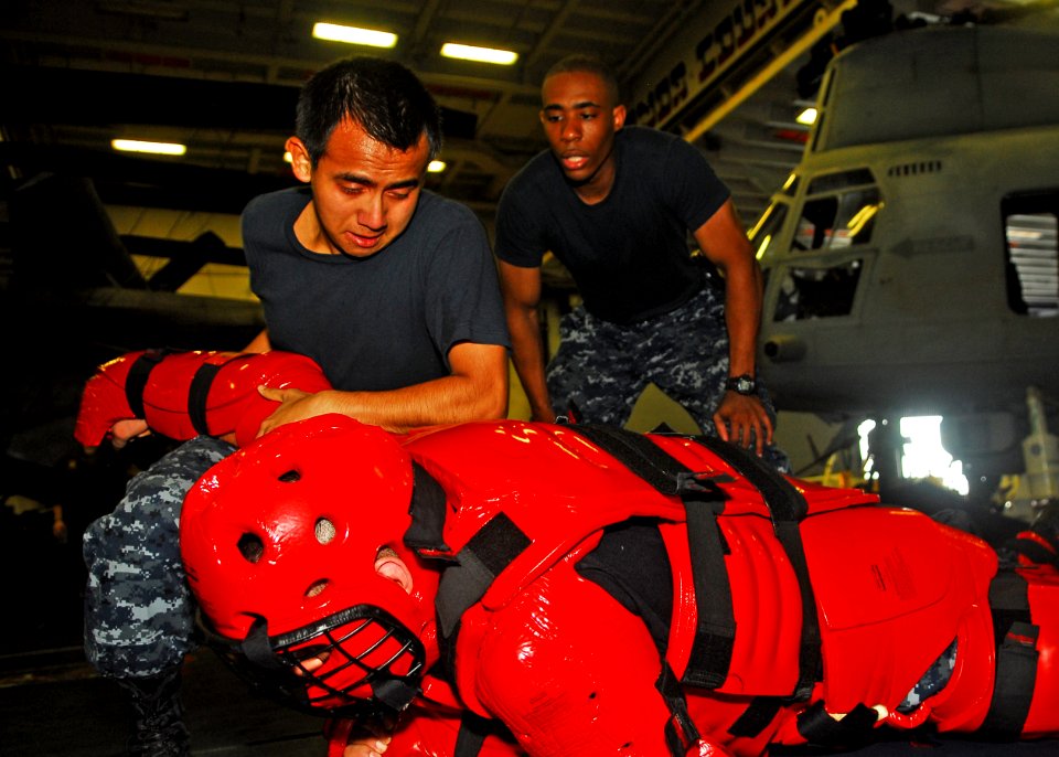 US Navy 101007-N-2218S-149 Yeomen Seaman Recruit Victor Navarro takes down Master-at-Arms 2nd Class Dereck Stern, during an oleoresin capsicum spra