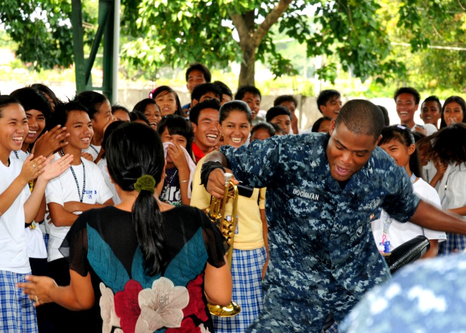 US Navy 101014-N-7783B-035 U.S. Navy Musician 3rd Class Michael Bookman, assigned to the U.S. 7th Fleet Band, Orient Express, dances with students