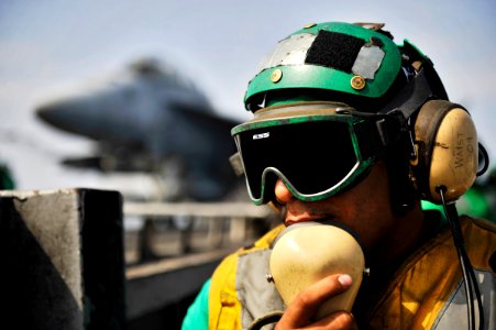 US Navy 101013-N-6003P-170 Aviation Boatswain's Mate (Equipment) 3rd Class David Aponte, a deck edge operator, communicates with catapult control b