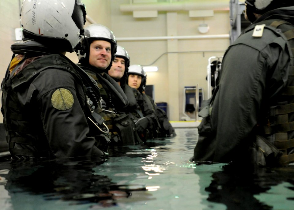 US Navy 101013-N-5787K-051 Students at Aviation Survival Training Center prepare to submerge themselves in full gear to simulate worst-case scenar