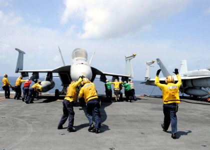 US Navy 101013-N-4973M-195 Sailors aboard the Nimitz-class aircraft carrier USS Abraham Lincoln (CVN 72) push a F-A-18F Super Hornet assigned to th