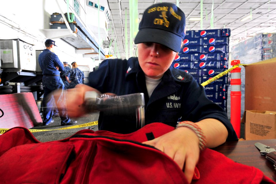 US Navy 101013-N-2953W-278 Boatswain's Mate 3rd Class Hilary Luke performs float coat maintenance in the hangar bay of the aircraft carrier USS Car