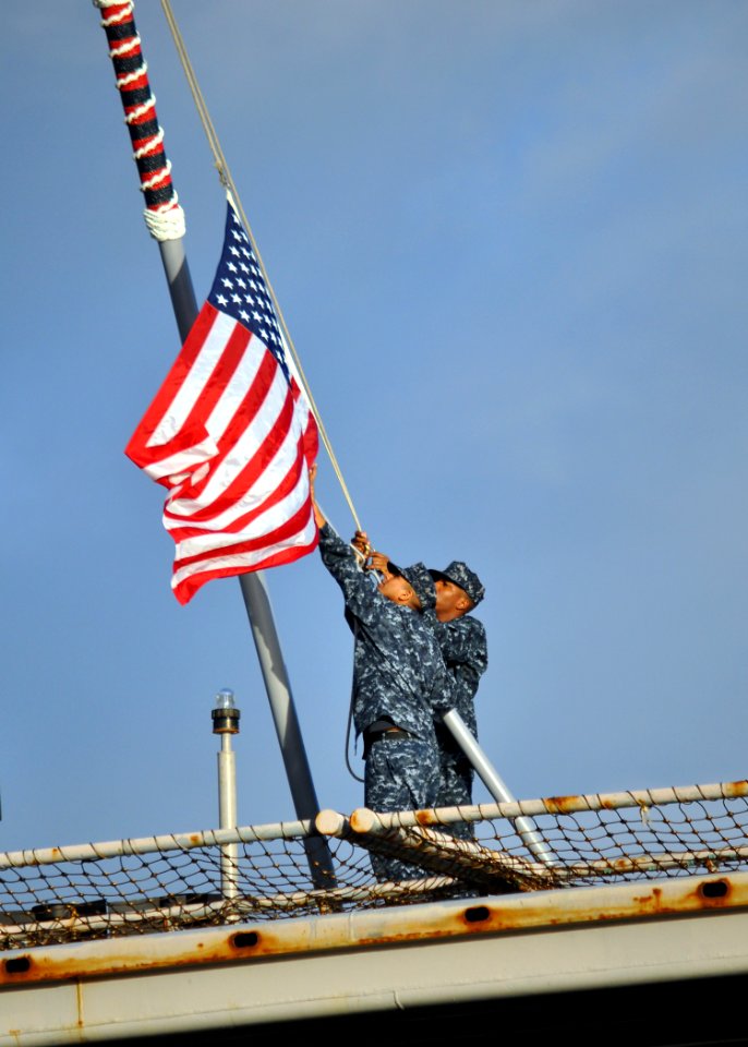 US Navy 111128-N-YC845-329 Sailors lower the national ensign as the amphibious transport dock ship USS Ponce (LPD 15) departs Naval Station Norfolk