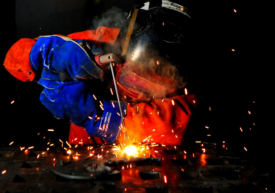 US Navy 101013-N-7948R-264 Hull Technician Fireman Tristan Reynolds arc-welds a flange aboard the amphibious dock landing ship USS Pearl Harbor (LS