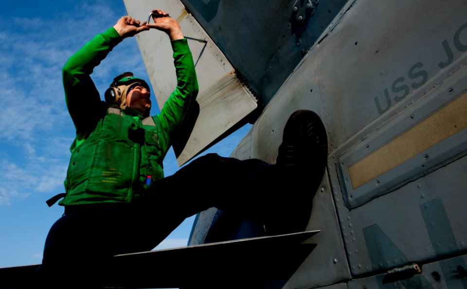 US Navy 111126-N-OY799-086 Aviation Structural Mechanic 2nd Class Chris Spruill tightens screws on an F-A-18C Hornet assigned to the Golden Dragons