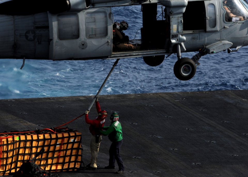 US Navy 101013-N-6427M-102 Sailors aboard the aircraft carrier USS Harry S. Truman (CVN 75) connect cargo to an MH-60S Sea Hawk helicopter assigned