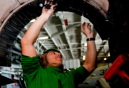 US Navy 111126-N-OY799-463 Aviation Machinist's Mate Airman Julian Barrera installs a variable exhaust nozzle strap on an F-A-18C Hornet assigned t