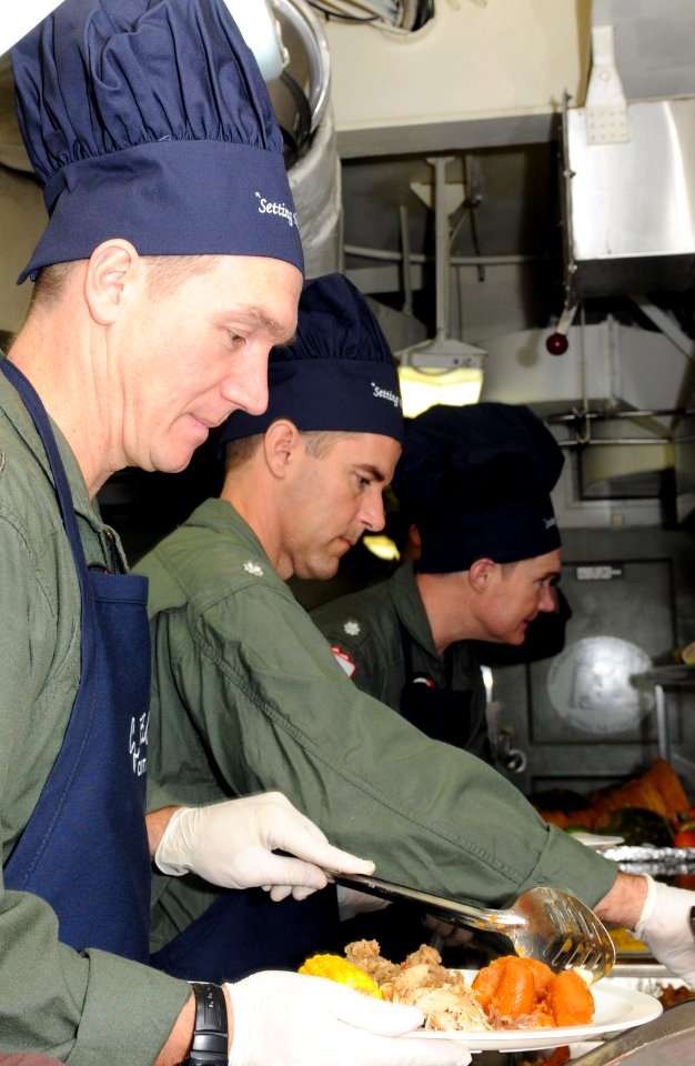 US Navy 111124-N-YC505-068 Officers serve Thanksgiving dinner in a galley aboard the aircraft carrier USS George H.W. Bush (CVN 77)