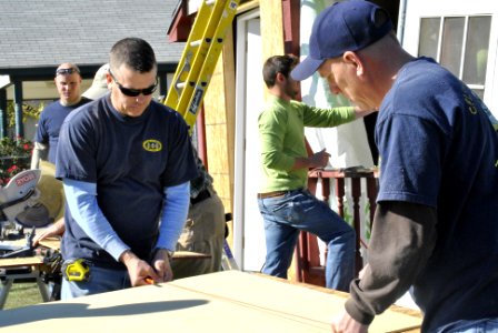 US Navy 111130-N-GO535-944 Chief Naval Aircrewman Chris Altizer and Chief Aviation Electrician's Mate Keith Warren mark a piece of wood before cutt
