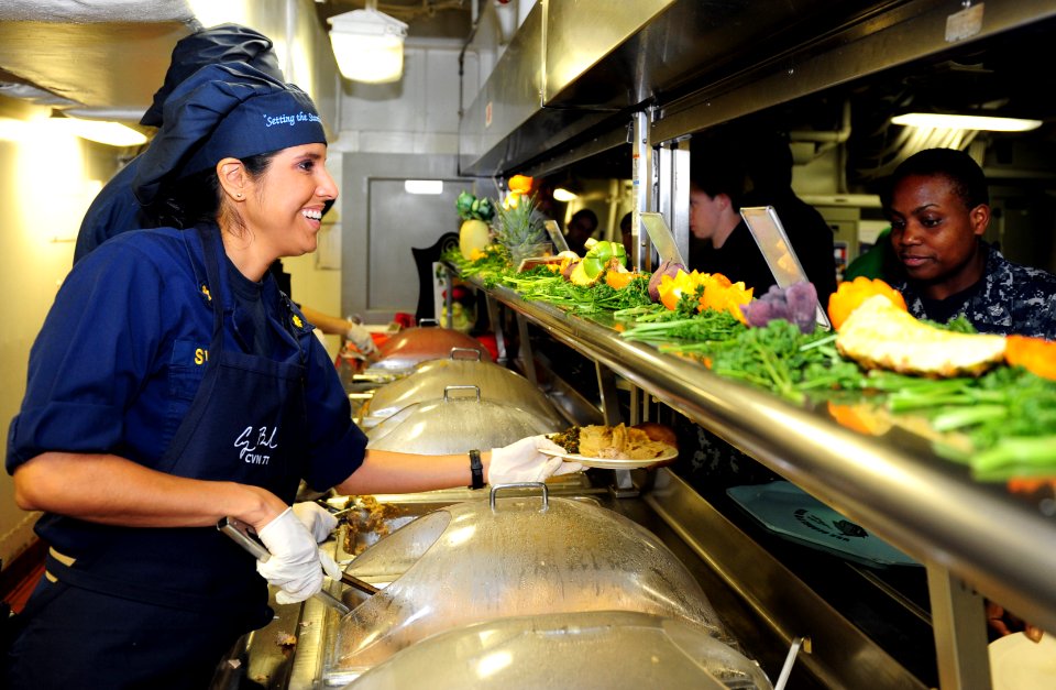US Navy 111124-N-Ql471-071 Lt. Cmdr. Herlinda K. Sweeney, the ship's Public Affairs Officer, serves a Thanksgiving meal to Aviation Electrician's M