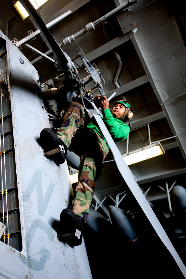 US Navy 111201-N-OY799-067 Aviation Machinist's Mate 2nd Class Huytuan Nguyen, from San Diego, works on the tail rotor of an MH-60S Sea Hawk helico