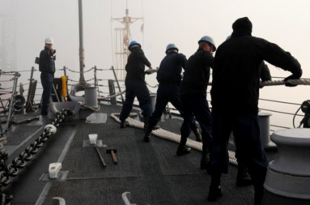 US Navy 111128-N-XQ375-018 Chief Boatswain's Mate Shawn Gray, left, observes as Sailors heave around a line on the forecastle of the guided-missile