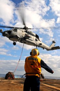 US Navy 111129-N-YM590-059 Boatswain's Mate Seaman Apprentice Jabari Hosten directs an SH-60B Sea Hawk helicopter, assigned to Helicopter Maritime
