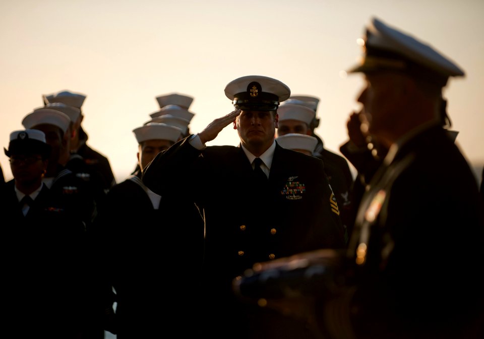US Navy 111201-N-DR144-552 Chief Aviation Boatswain's Mate (Handling) Luke Willdigg and other Sailors assigned to the burial detail render honors