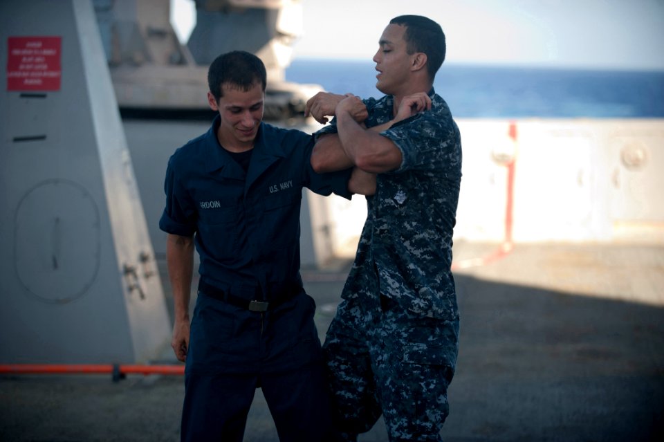 US Navy 111201-N-PB383-090 Engineman 3rd Class Phillip Nieves puts Hull Technician Fireman Nicholas Ardoin into an arm restraint during a self-defe