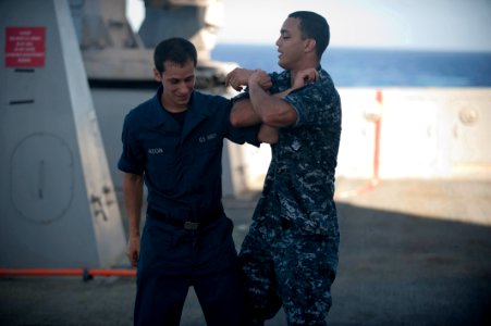 US Navy 111201-N-PB383-090 Engineman 3rd Class Phillip Nieves puts Hull Technician Fireman Nicholas Ardoin into an arm restraint during a self-defe