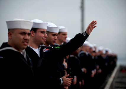 US Navy 111130-N-DR144-800 A Sailor waves goodbye to loved ones on the pier while manning the rails as the Nimitz-class aircraft carrier USS Carl