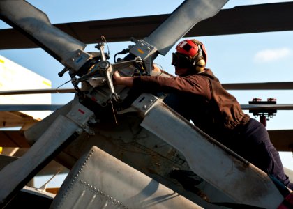 US Navy 111130-N-BT887-003 A Sailor wipes down the tail rotor of an MH-60R Sea Hawk helicopter assigned to the Raptors of Helicopter Maritime Strik