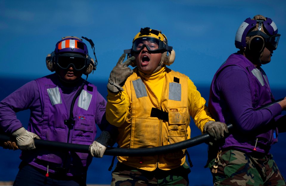 US Navy 111129-N-PB383-610 Aviation Boatswain's Mate (Fuel) 3rd Class James Lising calls for two additional hose men during a fire drill on the fl