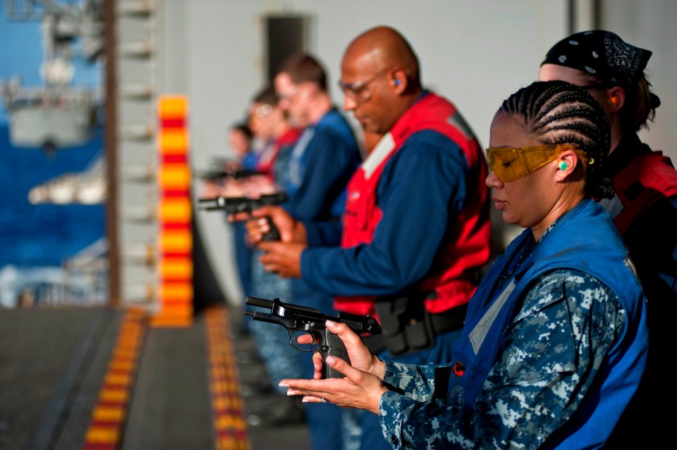 US Navy 111129-N-DX615-318 Aviation Boatswain's Mate 3rd Class Shante Moore reloads a 9mm pistol during a small arms qualification aboard the multi