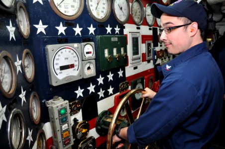US Navy 111201-N-YX169-030 Machinist's Mate 3rd Class Dominic Otero mans the main throttle board in the forward engine room of the amphibious trans