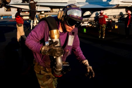 US Navy 111130-N-BT887-241 Aviation Boatswain's Mate (Fuel) Airman David Hayes carries a fuel hose aboard the Nimitz-class aircraft carrier USS Joh
