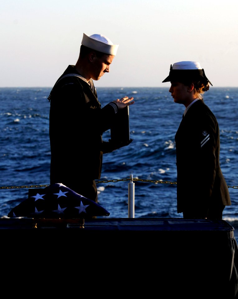 US Navy 111201-N-GZ277-234 Aviation Ordnanceman Airman Nathan Rings presents cremated remains to Religious Program Specialist Seaman Apprentice Ash