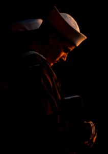 US Navy 111201-N-DR144-224 Aviation Ordnanceman Airman Nathan Rings bows his head in prayer before presenting cremated remains for committal during