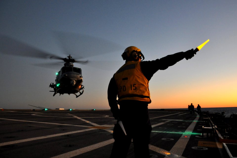 US Navy 111201-N-YX169-289 Aviation Boatswain's Mate (Handling) Airman Michael Babers directs a UH-1Y Venom helicopter, assigned to Marine Light At