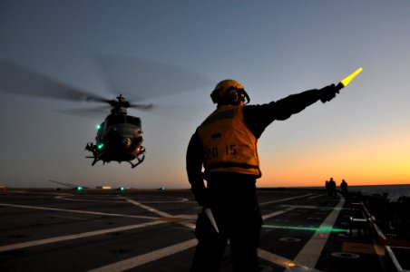 US Navy 111201-N-YX169-289 Aviation Boatswain's Mate (Handling) Airman Michael Babers directs a UH-1Y Venom helicopter, assigned to Marine Light At