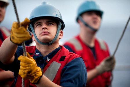 US Navy 111206-N-DR144-177 Fire Controlman 2nd Class Paul Sannes guides a missile canister as it is craned into place aboard the Nimitz-class aircr