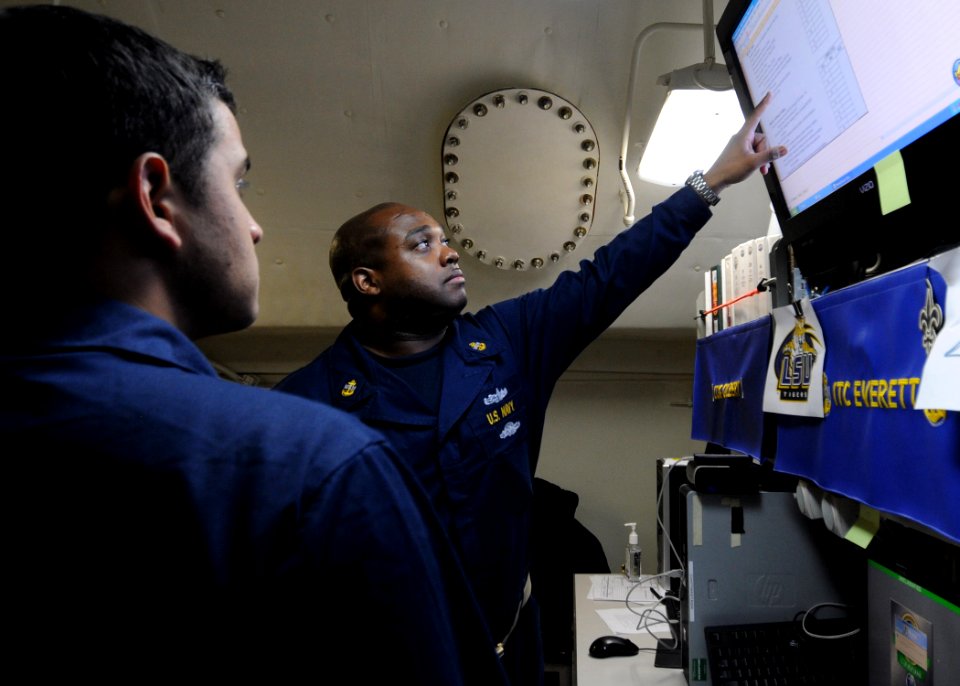 US Navy 111202-N-YC505-071 Chief Information Systems Technician Wilfred N. Everett, right, explains in-rate training curriculum updates to Informat